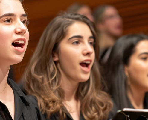 Langgestrecktes Bild. Über die gesamte Breite der Website hinweg. Zu sehen sind Mädchen die gemeinsam singen