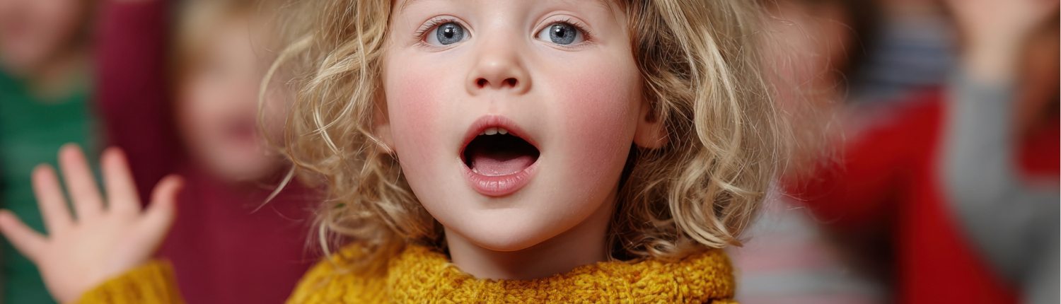 Im Vordergrund steht ein Mädchen das singt. Im Hintergrund stehen weitere musizierende Kinder